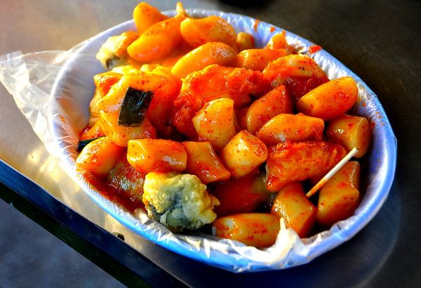 Bowl of spicy tteokbokki rice cakes in red sauce