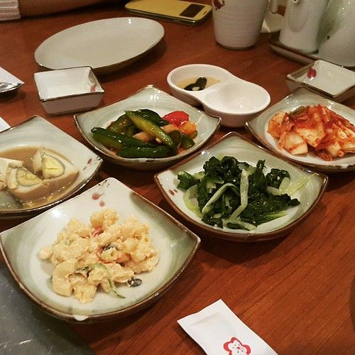 Table of Korean banchan side dishes with soju bottle