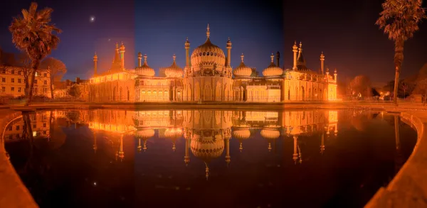 Traditional pavilion reflected in a pond, lit up at night