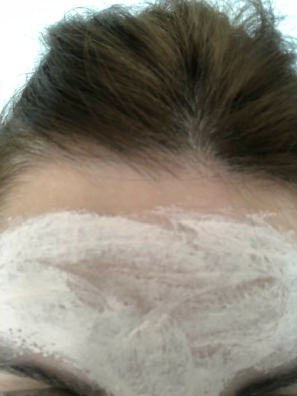 Person applying a hydrating sheet mask to their face