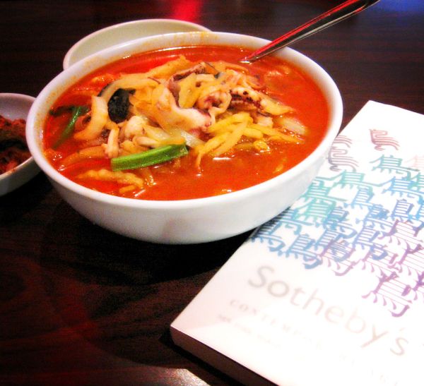 Bowl of spicy Korean stew and side dishes